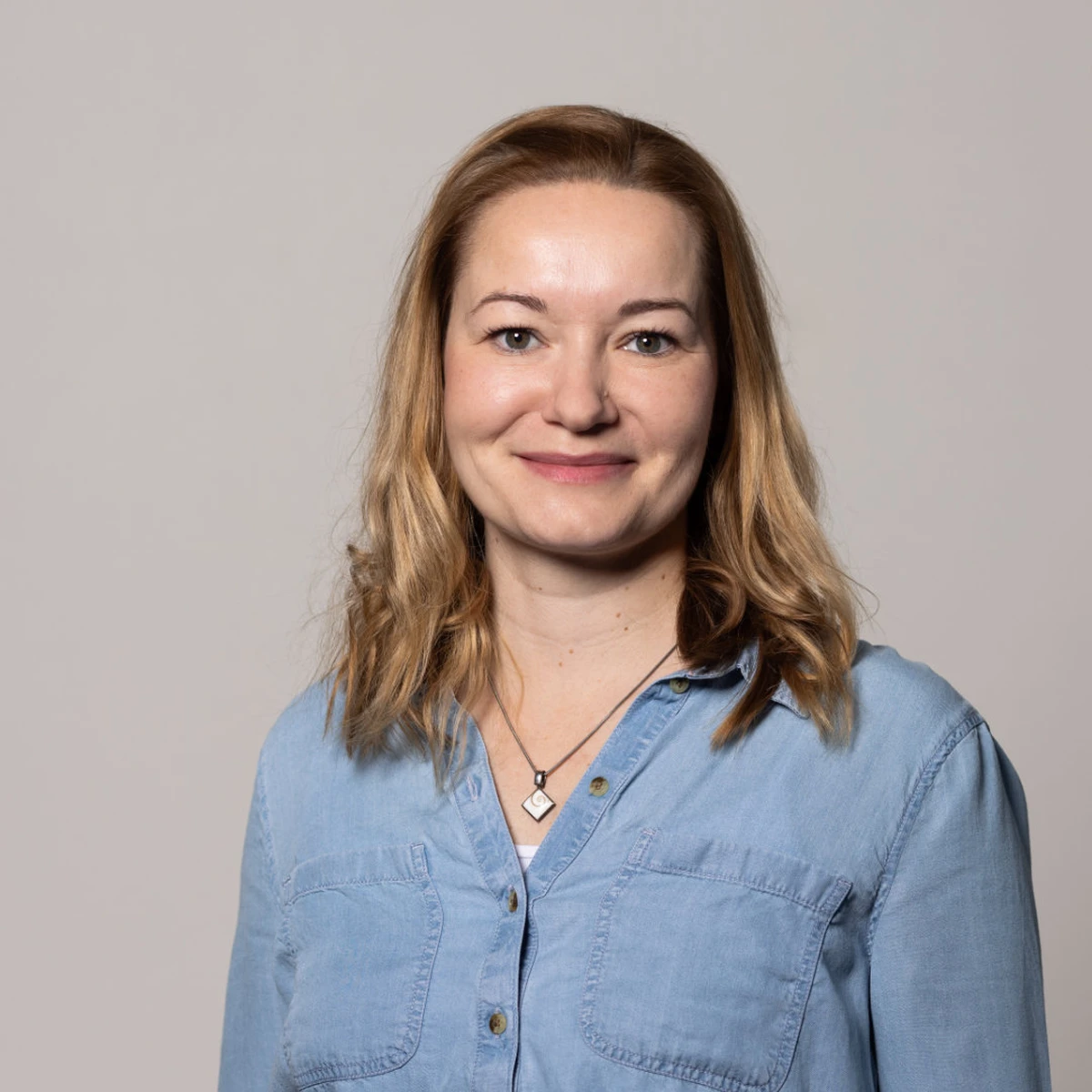 Portrait von Sabine Schuten – freundlich lächelnd mit blondem Haar und hellblauem Jeanshemd
