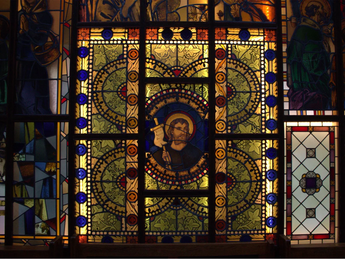 Nahaufnahme eines farbigen Glasfensters in der Kapelle des St. Josef Stifts, mit detaillierten Mustern und religiösen Darstellungen.