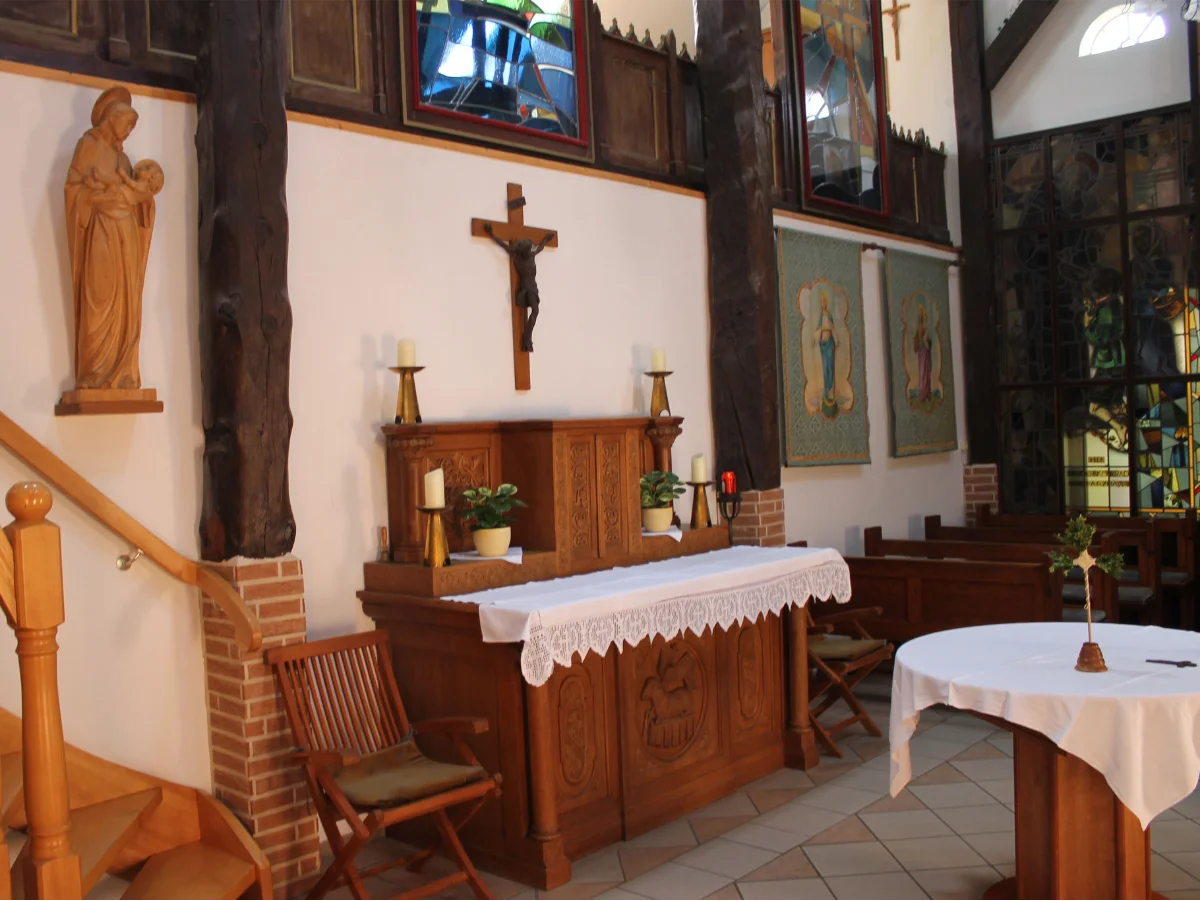 Altarbereich der Kapelle im St. Josef Stift mit Kreuzen, Kerzen und religiösen Figuren.